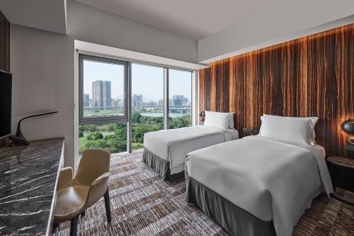 台北宿之酒店的酒店客房设有两张床和窗户。