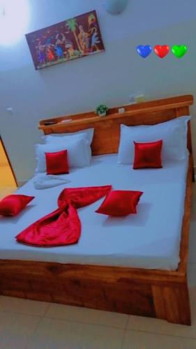 科托努Résidences Hôtel Perle Bleue的一间卧室配有红色枕头的床