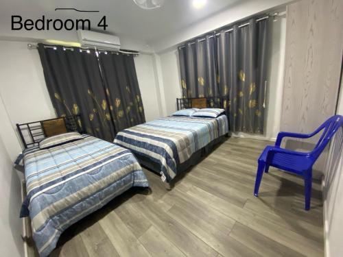 劳托卡Drasa Homestay的客房内的两张床和一张蓝色椅子