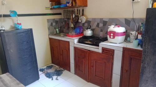 庞岸达兰Griya PAS Pangandaran的厨房配有木制橱柜和炉灶烤箱。