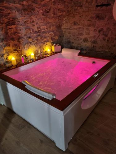 TresanaRosa di sera的客房内的热粉色浴缸配有灯