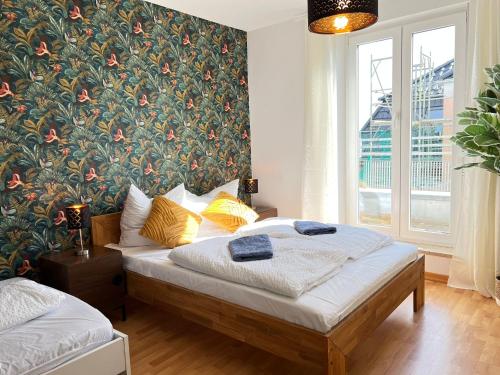 德累斯顿STARiVA - modernes Terrassen Apartment - Duplex Garage - Netflix的一间卧室设有一张床和花卉墙