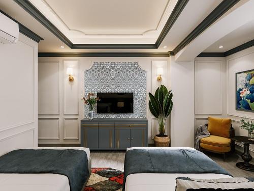 胡志明市Milestone Inn Hotel的客厅配有两张床和一台平面电视