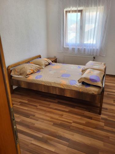 斯特鲁加Vreshtat e Liqenit-Ezerski Llozja的卧室内的一张床位,卧室设有窗户,铺有木地板