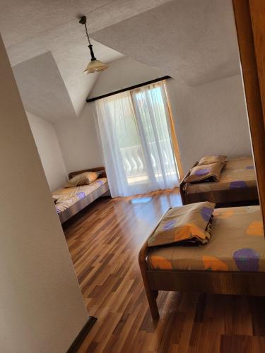 斯特鲁加Vreshtat e Liqenit-Ezerski Llozja的客房设有两张床和窗户。