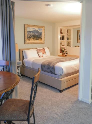 伊斯特海湾The Landmark Inn on Orcas Island的卧室配有1张床、1张桌子和1张桌子以及椅子。