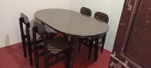 PudukkottaiHallima Residency NKS LODGE的一张桌子、四把椅子、一张桌子和一张桌子。