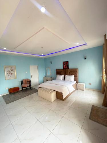 阿布贾Cozy And Serene Studio Apartment的一间卧室设有一张大床和蓝色的墙壁