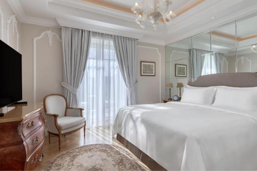雅典King George, a Luxury Collection Hotel, Athens的一间卧室配有一张大床和镜子