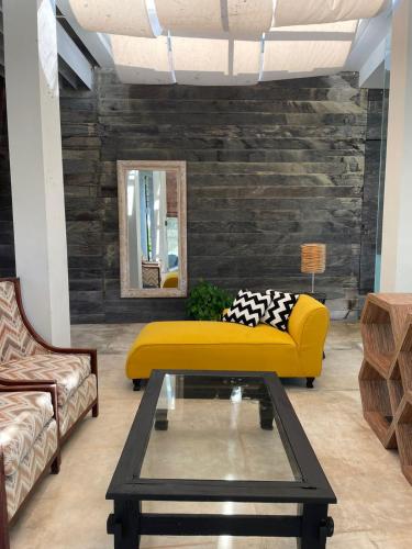 金巴兰New Kuta Suites的客厅配有黄色的沙发和桌子