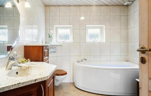 曲博伦5 Bedroom Gorgeous Home In Thyborn的带浴缸、盥洗盆和卫生间的浴室
