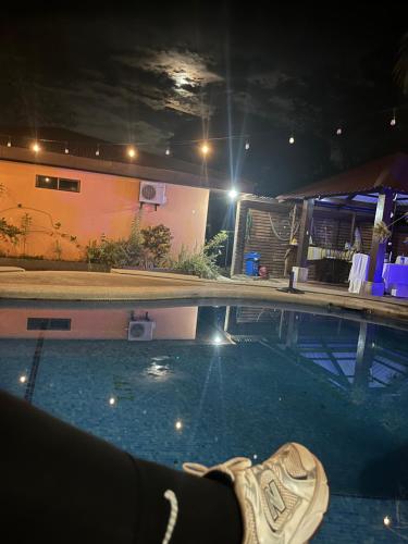 TapantíHotel Nacaome Blue Zone的夜间坐在游泳池里的鞋