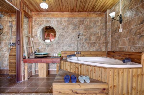 香格里拉香格里拉悠然山谷客栈(独克宗古城店)的带浴缸、水槽和镜子的浴室