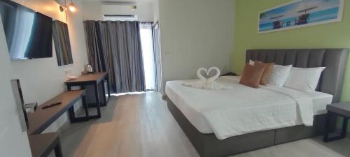 合艾Remas Hotel Hatyai的卧室配有白色的床和电视。