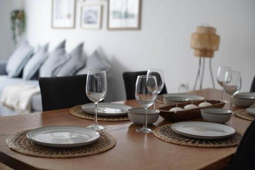 特拉维夫HaKerem new luxury 3 rooms apartments and 2 rooms penthaus的一张木桌,上面放有盘子和酒杯