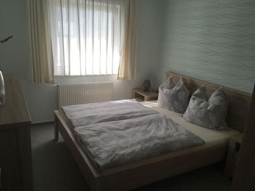 卢布明Strandhus Modern retreat的卧室配有带枕头的床铺和窗户。