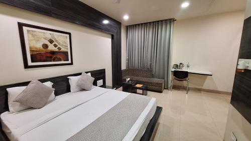 博帕尔Hotel Alankar Palace的卧室配有一张白色大床和一张书桌