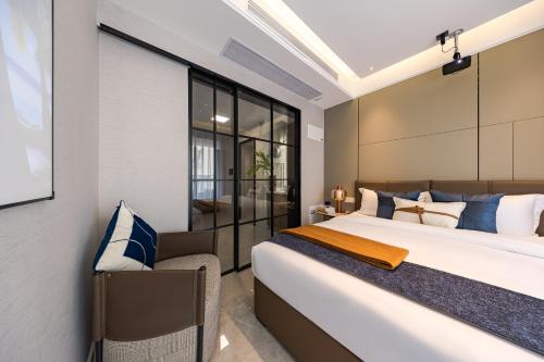 深圳玺客行政公寓酒店（深圳福田会展中心店）的一间卧室配有一张带蓝白色枕头的大床
