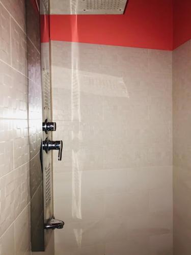 斯里贾亚瓦德纳普拉科特Royal Mount Residance的浴室设有红色和白色的墙壁,配有淋浴。