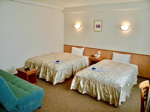 松江市Matsue Universal Hotel的酒店客房,设有两张床和一张沙发