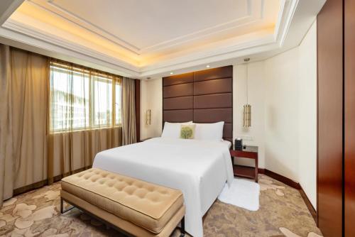 上海上海粤海酒店 的卧室配有白色大床和长凳
