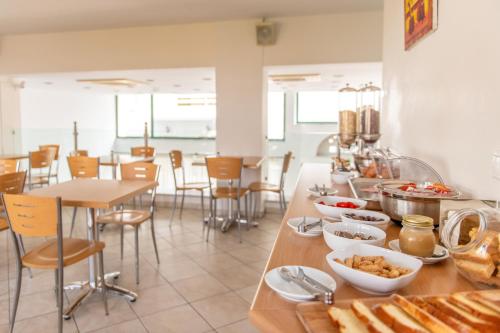 提诺斯Ageri Hotel的一间餐厅,配有餐桌和食物