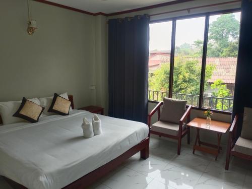 万荣Dokchampa Hotel的一间卧室设有一张床和一个大窗户