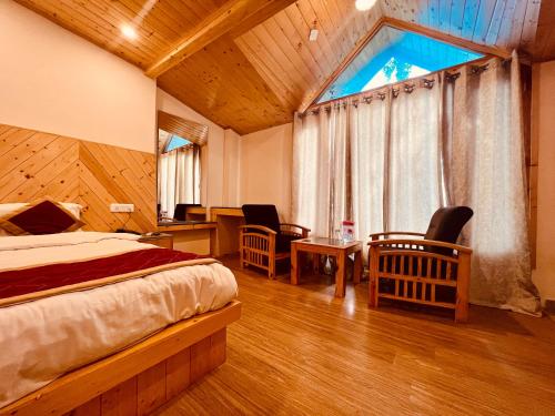 马拉里Manali Castle - Wonder Hill的一间卧室配有一张床、一张书桌和一个窗户。