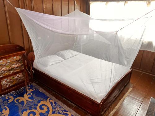 GanviéHotel Germain - Ganvié Holiday Resort的一间卧室配有带蚊帐的床