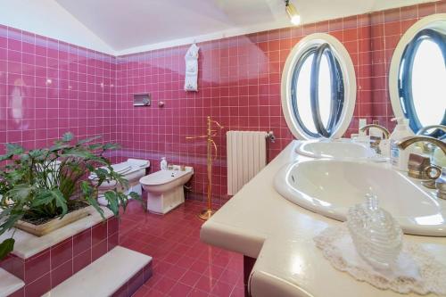 PellezzanoVilla Elvira的粉红色的浴室设有水槽和卫生间