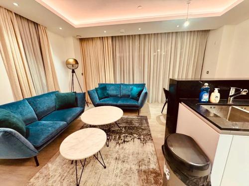 伦敦Luxury 2 Bedroom Apartment in Old Street, London的客厅配有蓝色的沙发和桌子