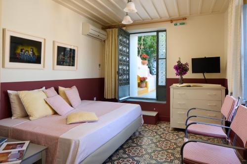 波罗斯Sto Roloi Island Houses的一间卧室设有一张床、一台电视和一个窗口。
