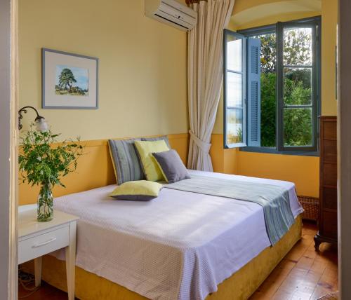 波罗斯Sto Roloi Island Houses的一间卧室设有一张床和两个窗户。