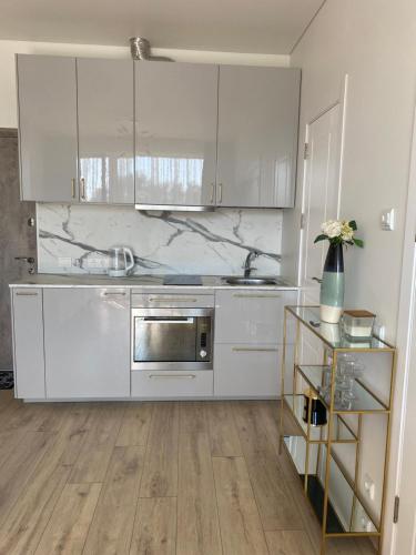 帕兰加Kunigiškiai Mano Jūra2 apartamentai的厨房配有白色橱柜和不锈钢用具