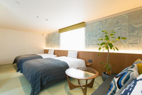 仓敷Nagi Kurashiki Hotel&Lounge的酒店客房设有两张床和窗户。