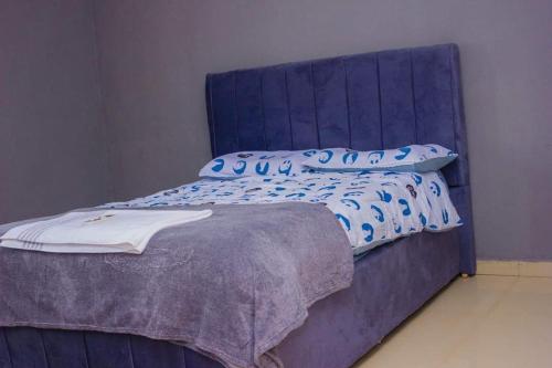 恩多拉Itawa Apartments的蓝色的床,上面有蓝色枕头