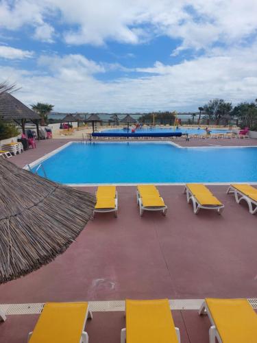 拉特斯Au lac des rêves的一个带黄色躺椅的游泳池,一个度假胜地