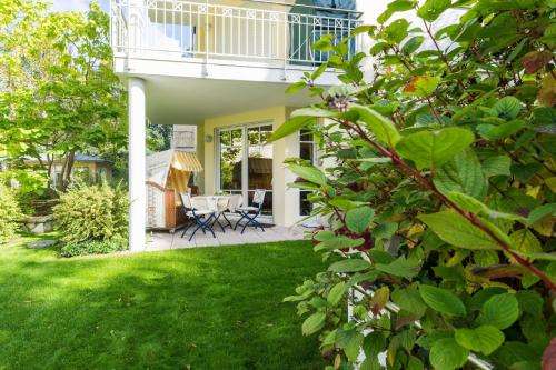 黑灵斯多夫Villa Charlotte App_13的带阳台的房子和绿草庭院