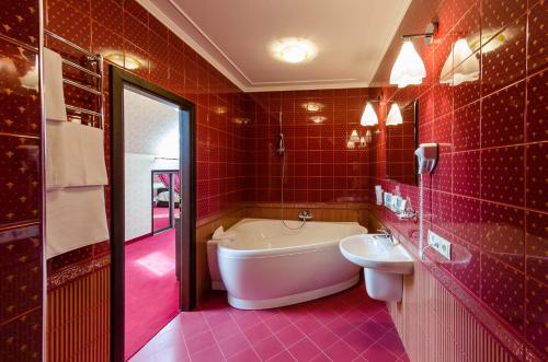 伊万诺-弗兰科夫斯克Franz Hotel&Restaurant的红色的浴室设有浴缸和水槽
