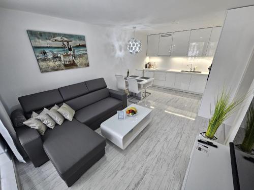 波普拉德Apartmány Urban的一间带黑色沙发的客厅和一间厨房