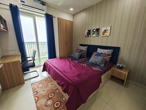 诺伊达Sandal suite by Mulberry Homestays的一间卧室配有一张带紫色床单的床和窗户。