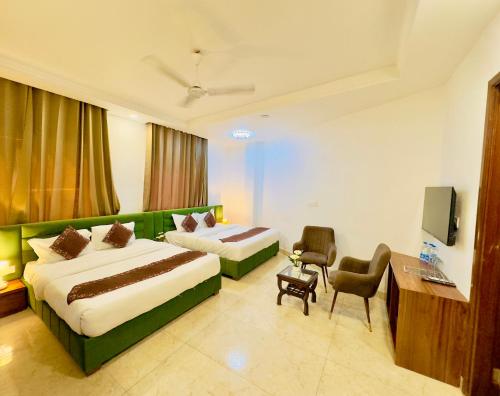 阿姆利则Hamilton Hotel & Resort, Near Golden Temple Parking Amritsar的酒店客房设有两张床和电视。
