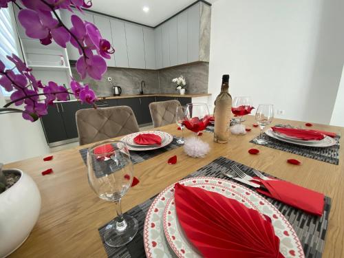 莫斯塔尔Apartman Pranić的餐桌,配有红色餐巾和酒杯