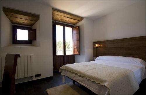 桑托多明戈德锡洛斯Hospederia Convento San Francisco的卧室配有白色的床和窗户。