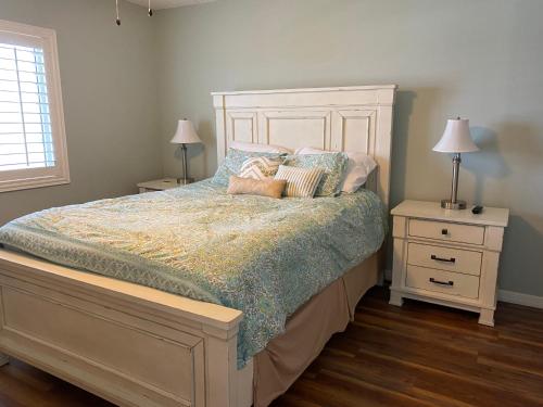 新士麦那海滩Pelican Condominium的一间卧室配有带枕头的床和2个床头柜
