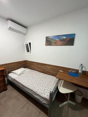 埃普拉特约布里加Cozy room next to el prat airport的一张床位,位于带书桌和床的西德西德西德(Sidx sidx)客房内