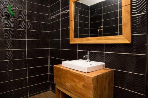 科托努New Green Horse Hotel的一间带水槽和镜子的浴室