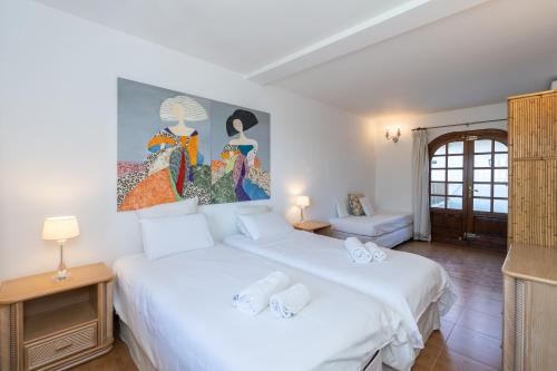 马贝拉Casa El Maizal的一间卧室设有两张床,墙上挂着一幅画
