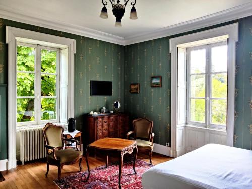 TorfouVALLÉE 1900的卧室配有一张床和一张桌子及椅子