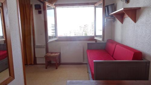 蒂涅BORSAT 4的窗户房间里一张红色的沙发
